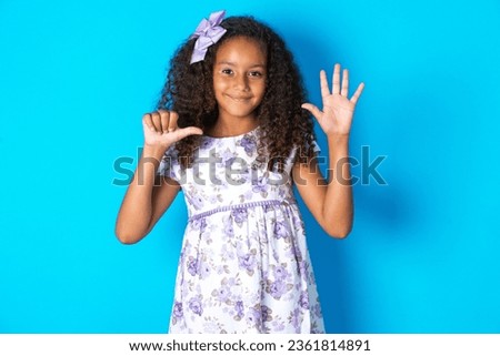 beautiful kid girl with afro curly hairstyle wearing flowered dress showing and pointing up with fingers number six while smiling confident and happy.