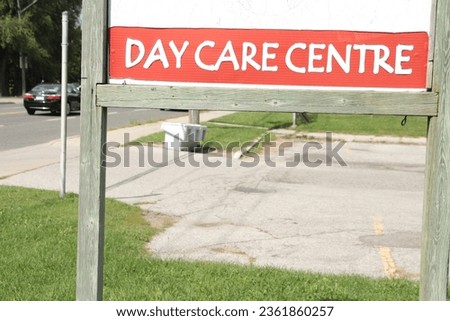 day care centre center sign on wood posts with wood frame outside exterior outdoors with road behind Royalty-Free Stock Photo #2361860257