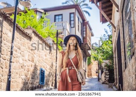 Happy woman tourist on background of old street of Antalya. female tourist traveler discover interesting places and popular attractions and walks in the old city Kalechi of Antalya, Turkey. Turkiye