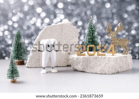 cartoon model of a tooth, the numbers 2024 and a Christmas deer on a podium made of stone and Christmas trees on a background of silver bokeh