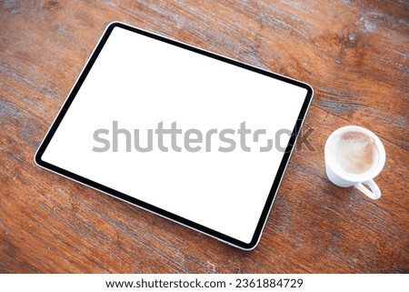 Digital tablet on wooden table, blank white screen mockup