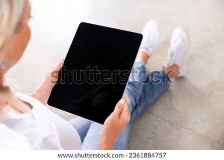 Woman using digital tablet, blank screen mockup