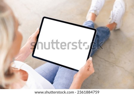 Woman using digital tablet, blank white screen mockup