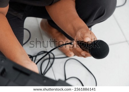 Hand holding a wired mic