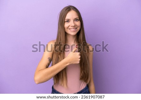 Young Lithuanian woman isolated on purple background giving a thumbs up gesture
