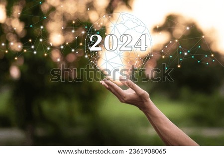 hand holding world network and text 2024 with blurred background, social network innovation technology new year new thing concept