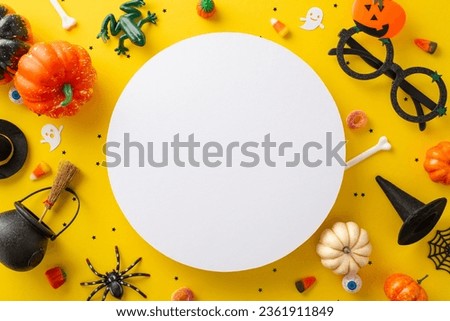 Join in the kids' trick or treating excitement. Overhead view snapshot displaying candies and Halloween decorations on a yellow isolated backdrop, great for text or advert integration