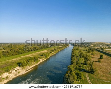 Aerial view of Sava river rapids, on the eastern side of Zagreb city, Croatia, with hidden, green oasis of Sava river tributaries behind heating plant Royalty-Free Stock Photo #2361916757