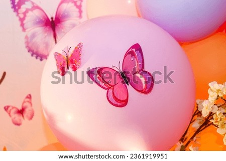 Butterflies cut out of paper on a colored balloons background.