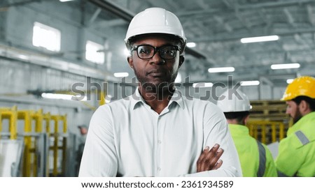 Close-up portrait of skilled experienced qualified African-American male engineer worker. Smart intelligent wise brainy man wearing fashionable glasses standing during work process. Royalty-Free Stock Photo #2361934589