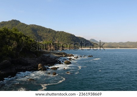 rocky seashore with rocky mountain, blue sea and sky. asia beach 