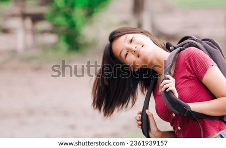 Female nature tourist carries a backpack on her shoulder. Traveling during high season with happiness and freedom A way to live life without limits