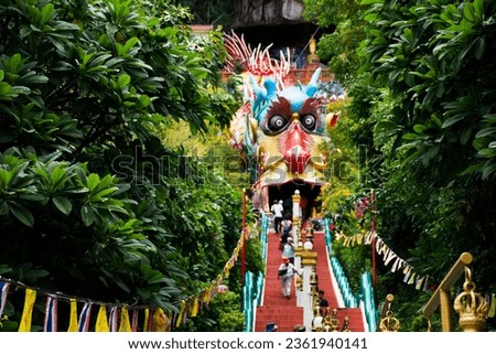 Antique red stairs of Chinese Dragon Tunnel to Ku Ha Mangkorn Sawan or Bua Kli Cave of Wat Ban Tham temple for thai people travel visit respect praying blessing holy mystical in Kanchanaburi, Thailand Royalty-Free Stock Photo #2361940141