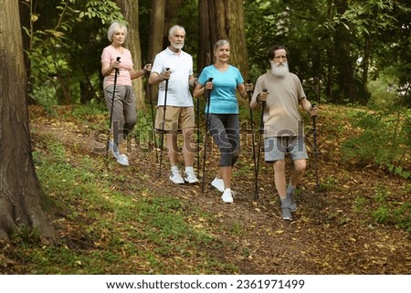 Group of senior people performing Nordic walking in forest