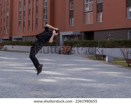 Man taking photos while doing somersault outdoors. 