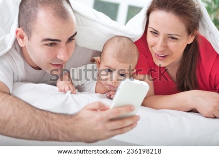 Adorable family using mobile at home