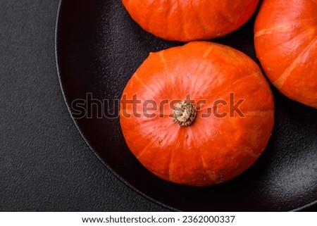 Beautiful fresh round pumpkins in orange color on a dark concrete background. Preparing for the Halloween celebration