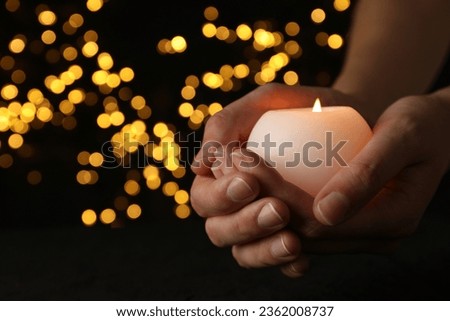 Mourning candles in hands, on a dark background. Royalty-Free Stock Photo #2362008737