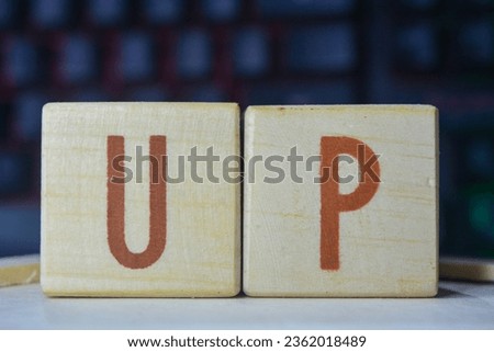 Photo of wooden blocks that make up the vocabulary "UP" in English