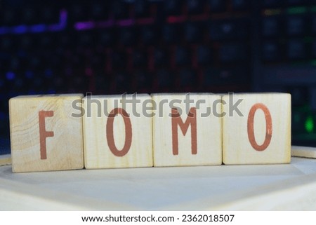 Photo of wooden blocks that make up the vocabulary "FOMO" in English