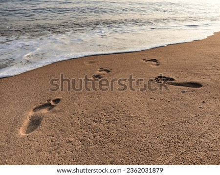 photo of footprints on the beach sand