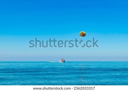 parasailing. ride on a colored parachute attached to a motor boat. 