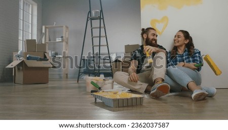Cheerful young couple in the morning at home. Newlywed caucasian couple are relaxing during renovation of their new home and positively smiling - new life, mortgage concept Royalty-Free Stock Photo #2362037587