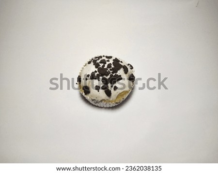 Sweet little bread bakery cake with white chocolate topping and chunks of biscuits isolated on white background with copy space for text photo image. 