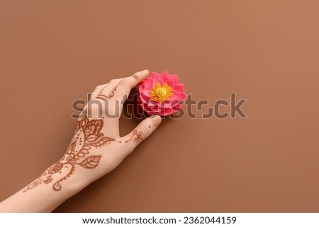 Female hand with lotus flower for celebration of Divaly on brown background