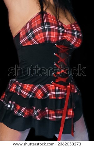 The body of an adult woman in a black dress in a red check, light erotica, concept. Royalty-Free Stock Photo #2362053273