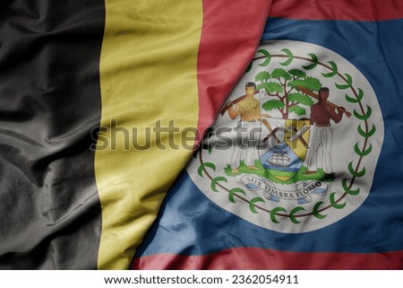 big waving national colorful flag of belgium and national flag of belize . macro