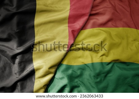 big waving national colorful flag of belgium and national flag of bolivia . macro