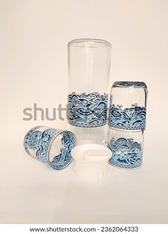 Set of empty transparent glasses cup and cattle with blue batik pattern decoration from indonesia isolated on white background  photo image
