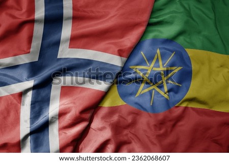 big waving national colorful flag of norway and national flag of ethiopia . macro