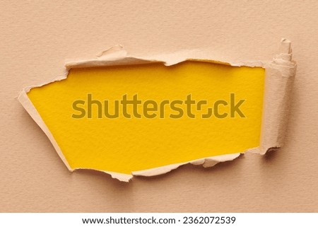 Frame of ripped paper with torn edges. Window for text with copy space yellow beige colors, shreds of notebook pages. Abstract background
