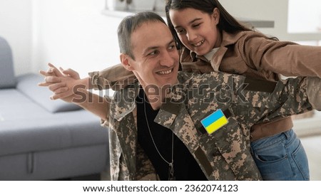 Father in Ukrainian military uniform and his daughter. Family reunion