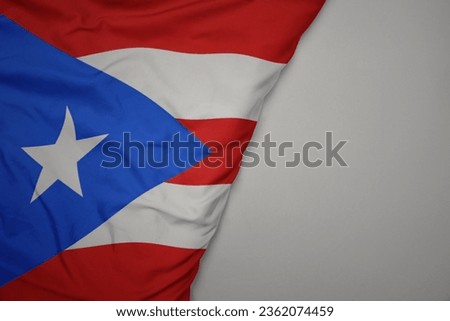 big waving national colorful flag of puerto rico on the gray background. macro