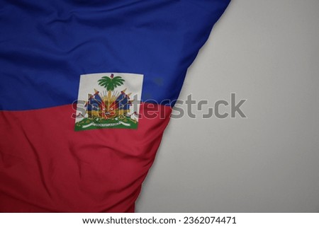 big waving national colorful flag of haiti on the gray background. macro