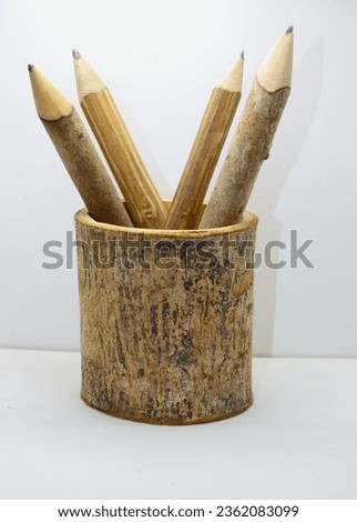 Wood twig pencils in In a pencil holder made from a piece of natural branch with natural outer bark  isolated on white background Branches of cinnamon tree and tea tree have been used