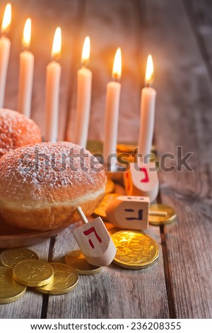 Jewish holiday hannukah symbols - menorah, donuts, chocolate coins and wooden dreidels. Copy space background.