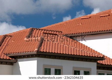 Closeup of house rooftop covered with ceramic shingles. Tiled covering of building Royalty-Free Stock Photo #2362104635
