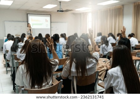 Rear view of college students listen to teacher teaching and explaining lesson in classroom Royalty-Free Stock Photo #2362131741