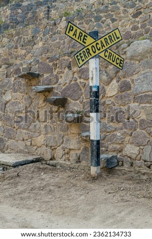 Sign of a railway crossing in Ollantaytambo village, Sacred Valley of Incas, Peru. It says: Stop. Railway crossing.