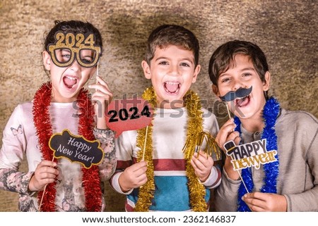 Three kids celebrating New Years Eve. 2024! Royalty-Free Stock Photo #2362146837