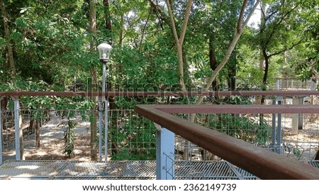 Suspension bridge for pedestrians located in the campus area of Universitas Gadjah Mada Yogyakarta: Usually used for sports. This place is named the "Wisdom Park" UGM. Royalty-Free Stock Photo #2362149739