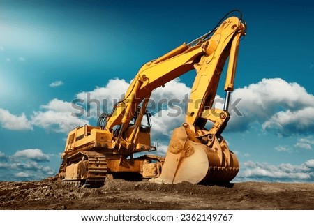 Large excavator on construction site on a sunny day with blue sky and fluffy clouds, cool modern look Royalty-Free Stock Photo #2362149767