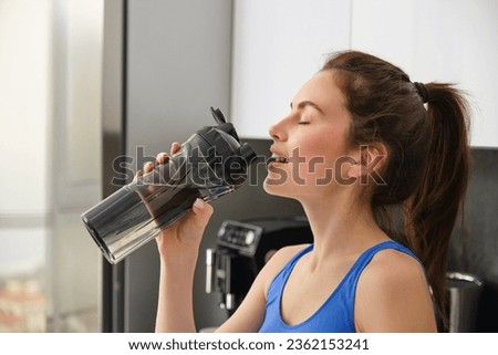Close up portrait of sportswoman face, fitness girl drinks water from sport bottle and smiling, hydrating after productive aerobics, yoga workout.