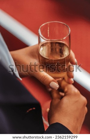 Celebrate milestones and achievements with a lively business team in a vibrant party setting. Woman holding a glass of champagne. Close up photo.
