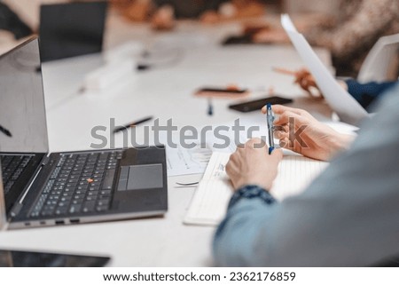 Close up photo of employee playing with pen while having a meeting at work