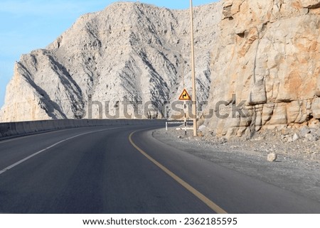 Take a virtual expedition through the breathtaking beauty of the Musandam Peninsula with this captivating stock photograph. Meticulously captured, this image showcases a scenic road.